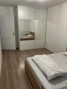 una camera con un letto e un grande specchio di Cosy appartement T3 meublé Aubervilliers - La Plaine ad Aubervilliers