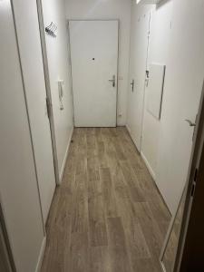 un corridoio con porte bianche e pavimento in legno di Cosy appartement T3 meublé Aubervilliers - La Plaine ad Aubervilliers