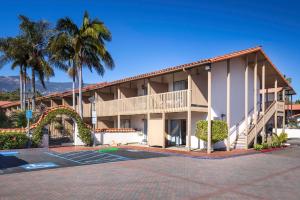 um edifício com uma palmeira e um parque de estacionamento em Best Western Plus Pepper Tree Inn em Santa Bárbara