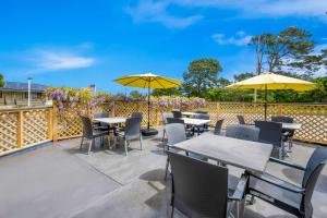 een patio met tafels, stoelen en parasols bij Best Western Park Crest Inn in Monterey