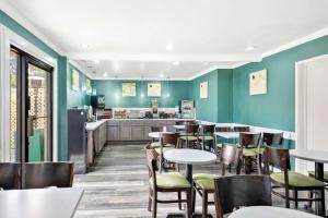 um restaurante com paredes verdes, mesas e cadeiras em Best Western Park Crest Inn em Monterey
