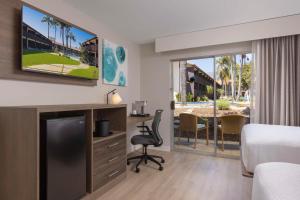 Habitación de hotel con cama, escritorio y TV. en Best Western Plus Pepper Tree Inn en Santa Bárbara