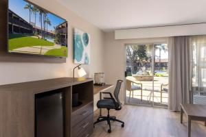 ein Wohnzimmer mit einem Schreibtisch und einem Tisch mit einem Stuhl in der Unterkunft Best Western Plus Pepper Tree Inn in Santa Barbara