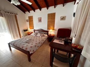 een slaapkamer met een bed, een tafel en een bureau bij Luna Azul in Merlo
