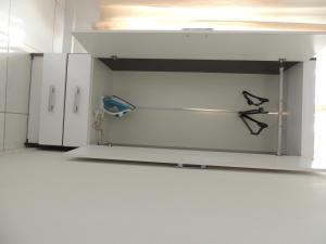 a white cabinet in a kitchen with two birds on it at room itaim in Sao Paulo