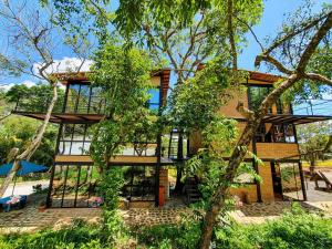 a house with glass windows and a tree at Villas del bambú in San Gil