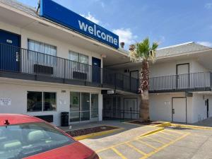 a hotel with a palm tree in front of a building at Motel 6-Odessa, TX in Odessa