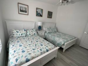 基拉戈的住宿－Waterfront Tropical Getaway，一间卧室配有两张床,还有一个床头柜和床架
