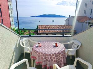uma mesa e cadeiras numa varanda com vista para o oceano em Amisos Boutique Hotel em Bečići