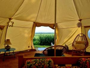 une grande tente avec un canapé et des chaises dans une chambre dans l'établissement Luna Tent Secret garden Glamping, 