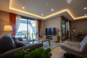 a living room with couches and a television and a table at Marje Villas Bodrum in Bodrum City