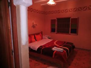 a red bedroom with a bed with red pillows at Dar Zara in Ouarzazate