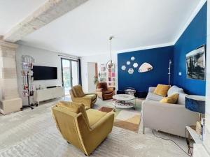 sala de estar con sofá, sillas y TV en Des vacances au Pontpadour !, en Entraigues-sur-la-Sorgue