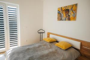 a bedroom with a bed with two yellow pillows at Apartmány Na Vŕšku in Kežmarok