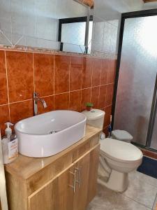 a bathroom with a white sink and a toilet at Acogedor Apartamento 2 alcobas cerca al mar in Puerto Salgar