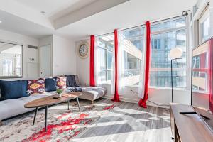 uma sala de estar com cortinas vermelhas e um sofá em Dan Leckie Apartments em Toronto