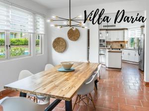 Una cocina y un comedor con mesa y sillas de madera. en Daria Beachfront community steps 2 pool- Generator, en Sabana