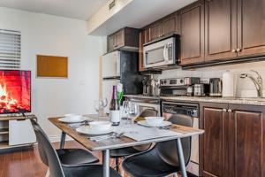 een keuken met een tafel met stoelen en een fornuis bij Fort York Residence in Toronto