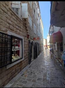 a stone alley way with a building and a storefront at D&M in Budva