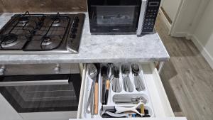 una cucina con piano cottura e bancone con utensili di Luxury 2 bedrooms flat Leytonstone a Londra