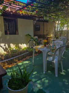 un patio con tavolo, sedie e piante di Pousada Residencial Porto de Galinhas a Porto De Galinhas