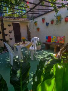un patio con mesa, sillas y plantas en Pousada Residencial Porto de Galinhas, en Porto de Galinhas
