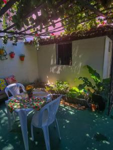 eine Terrasse mit einem Tisch und Stühlen sowie einem Garten in der Unterkunft Pousada Residencial Porto de Galinhas in Porto De Galinhas