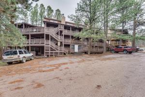 a large house with cars parked in front of it at Rustic Angel Fire Condo Resort Shuttle On-Site! in Angel Fire