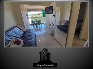 a living room with a blue couch and a kitchen at Apto climatizado 502, apenas 5 min das Thermas in Piratuba