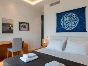 a bedroom with a bed with a blue painting on the wall at Villa Meraviglia Elia Mykonos in Elia Beach +91 photos