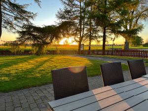 uma mesa e cadeiras com o pôr do sol num parque em Sydkustens at Lillehem em Skivarp