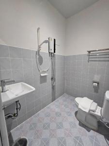 a bathroom with a shower and a toilet and a sink at Triple D Hotel in Betong