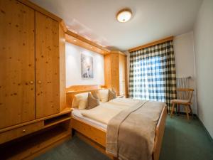 - une chambre avec un grand lit et un mur en bois dans l'établissement Pistenblick Forstau, à Forstau