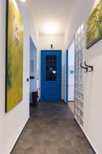 un couloir avec une porte bleue dans une maison dans l'établissement NONPERTUTTI PIAZZA CASTELLO Senior e famiglie TOP, à Turin
