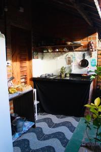 a kitchen with a stove and a counter top at Canoa Roots Hostel & Camping in Canoa Quebrada