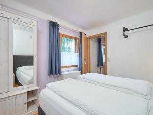 een slaapkamer met 2 bedden en een spiegel bij Zonnen-Alp in Forstau