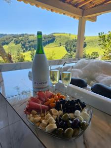 a plate of food and two glasses of wine at Sítio Ramos casa amarela in Cunha