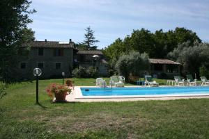 een zwembad in een tuin met stoelen en een huis bij Monte Del Lago in Magione