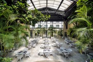 a restaurant with tables and chairs and palm trees at Loi Suites Recoleta Hotel in Buenos Aires