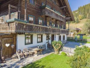 a large wooden house with a deck and a yard at Hauserbauer Small in Bramberg am Wildkogel