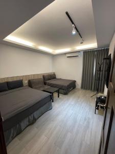 Habitación con 2 camas y sofá en 大鯨魚旅宿, en Isla Verde