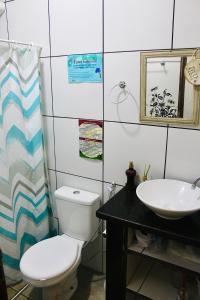 a bathroom with a toilet and a sink at Canoa Roots Hostel & Camping in Canoa Quebrada