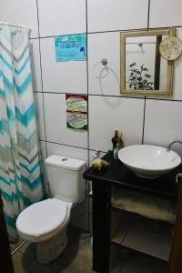 a bathroom with a toilet and a sink at Canoa Roots Hostel & Camping in Canoa Quebrada