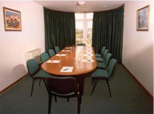 une salle de conférence avec une grande table et des chaises en bois dans l'établissement Hotel San Vicente, à Saint-Jacques-de-Compostelle