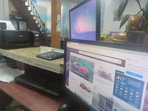 un monitor de ordenador y un ordenador portátil en un escritorio en V V Queens house, en Vang Vieng