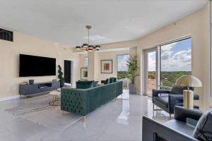 a living room with a green couch and a tv at FL King Velvet Suite- 3bdrm/2Bath-2000 sq ft in Orlando