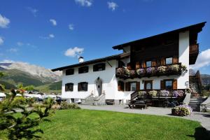 a large white building with flowers on the windows at Stella Alpina - Happy Rentals in Livigno