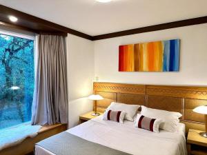 a bedroom with a large bed and a window at Fantástico Studio Royal Laje de Pedra MV (3022) in Canela
