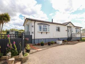 a white house with a black fence and plants at Seaward in Norwich