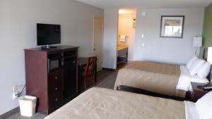 um quarto de hotel com duas camas e uma televisão de ecrã plano em Great Valley Inn em Union Gap